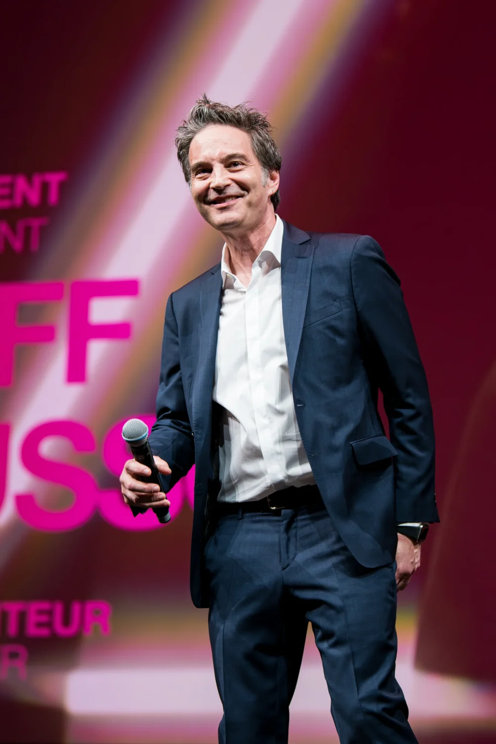 Homme en costume lors d'une remise de prix sur scène