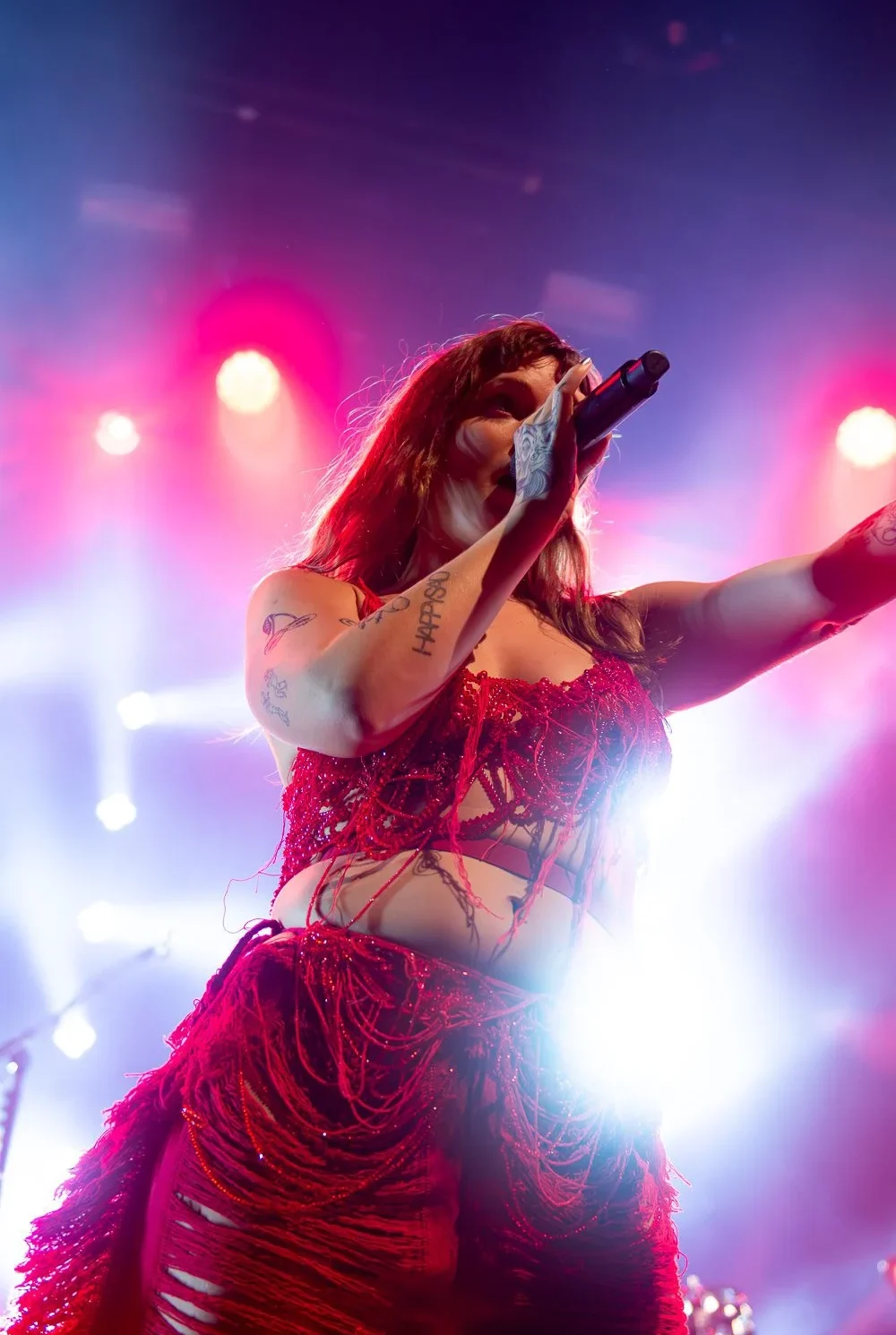 Tove Lo dansant sous un ciel de lumière, captivant le public parisien avec sa performance dynamique durant sa tournée européenne 2022.”